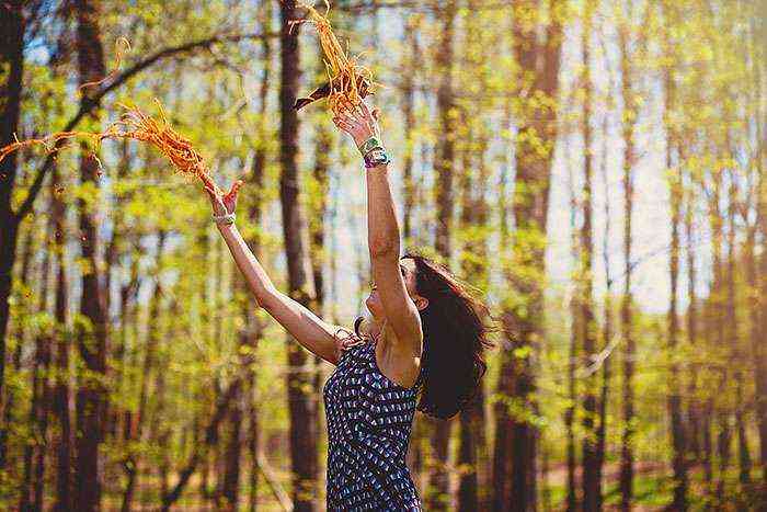 Mujer lanzando espaguetis en el bosque